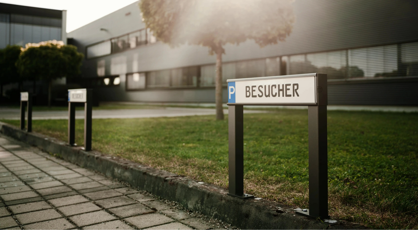 Parkplatz mit Kennzeichenhalterungen mit der Aufschrift Besucher